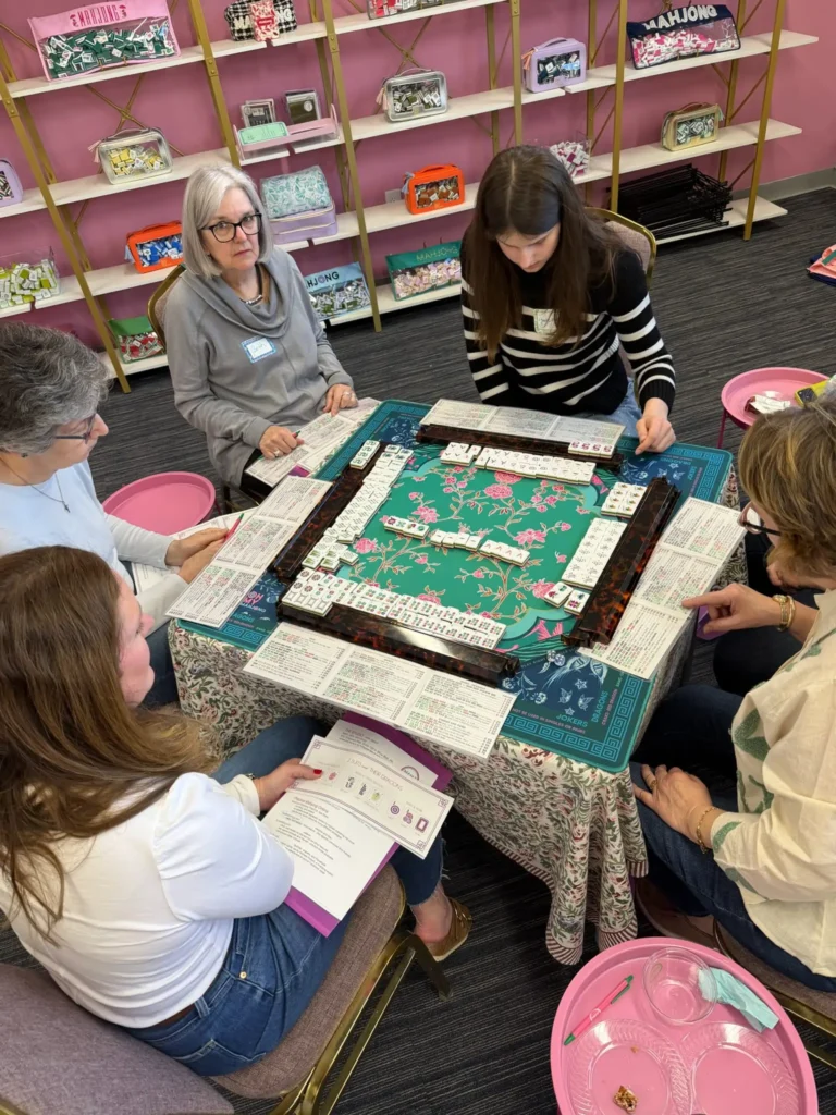 Group of women studying the mahjong game rules