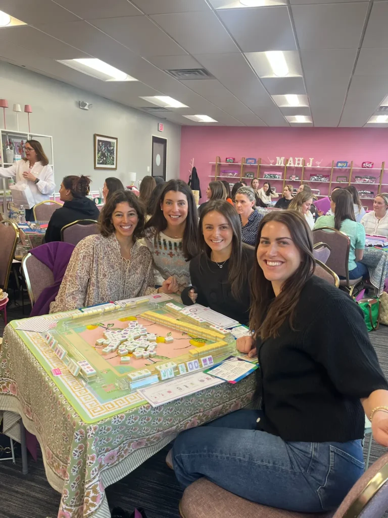 Smiling women learning to play mahjong