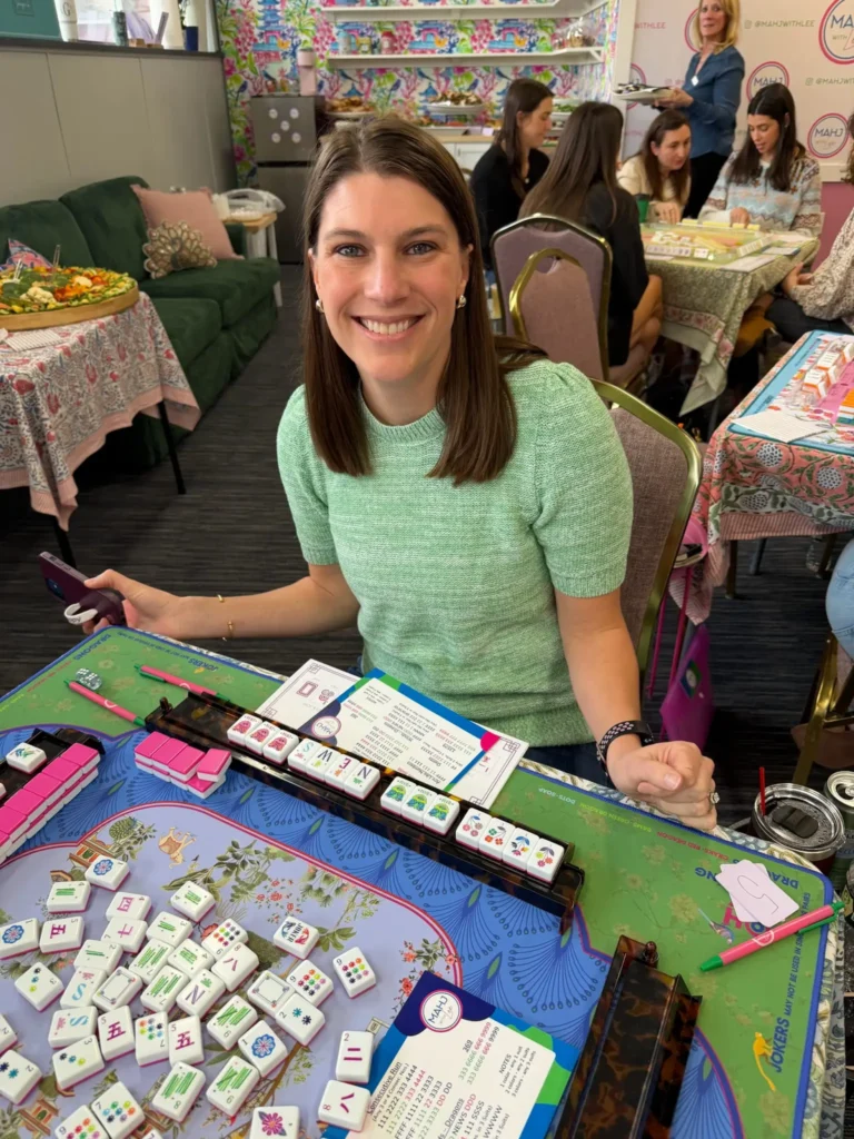 Woman in a green sweater with mahjong set